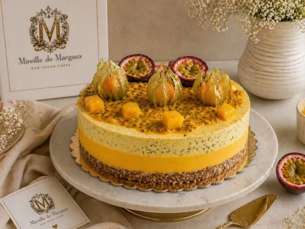 Tort Raw Vegan Mango și Fructul Pasiunii Mireille de Margaux, decorat cu fructul pasiunii, physalis și cuburi de mango